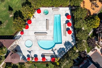An aerial view of a pool surrounded by red flowers at The Woods Apartments, San Jose, California