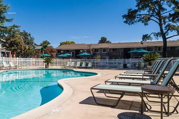 A pool area with sun loungers and a building in the background at Cherrywood Apartments, California, 95118