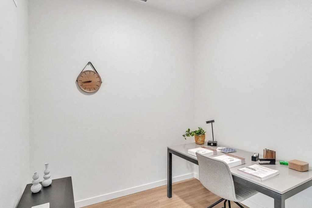 a home office with a desk and a wall clock