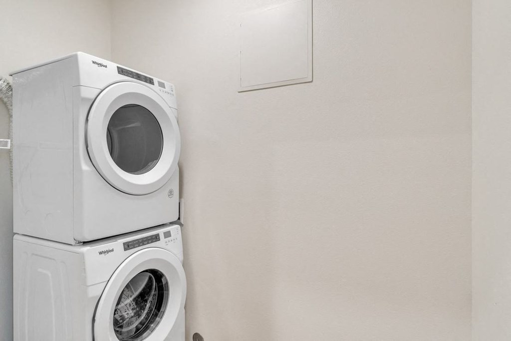 a white washer and dryer in a white laundry room with a white door