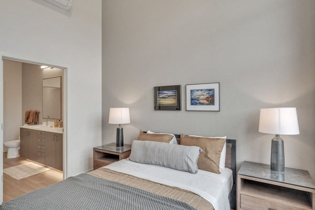 a bedroom with a bed and a bathroom with a mirror