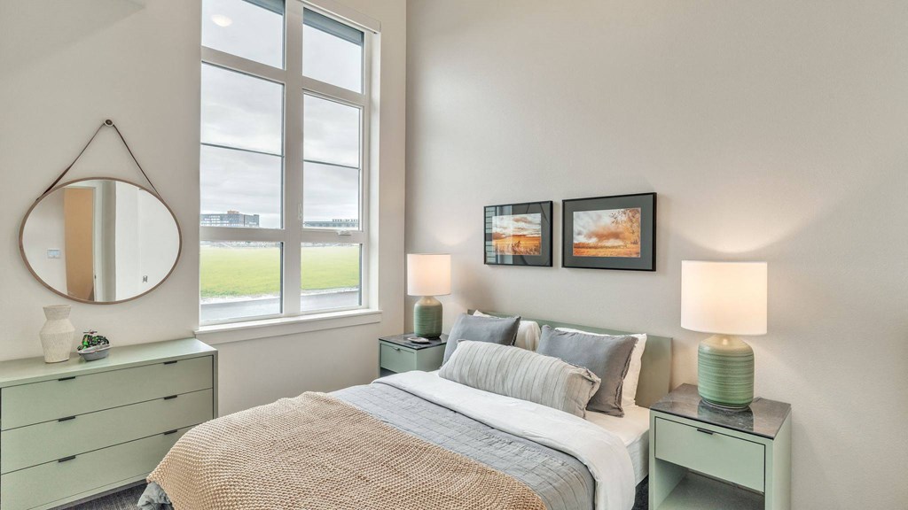 a bedroom with a bed and a large window