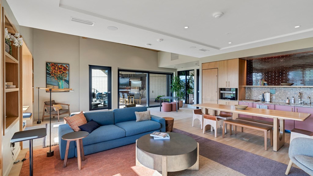 a living room and dining room with a blue couch and a table