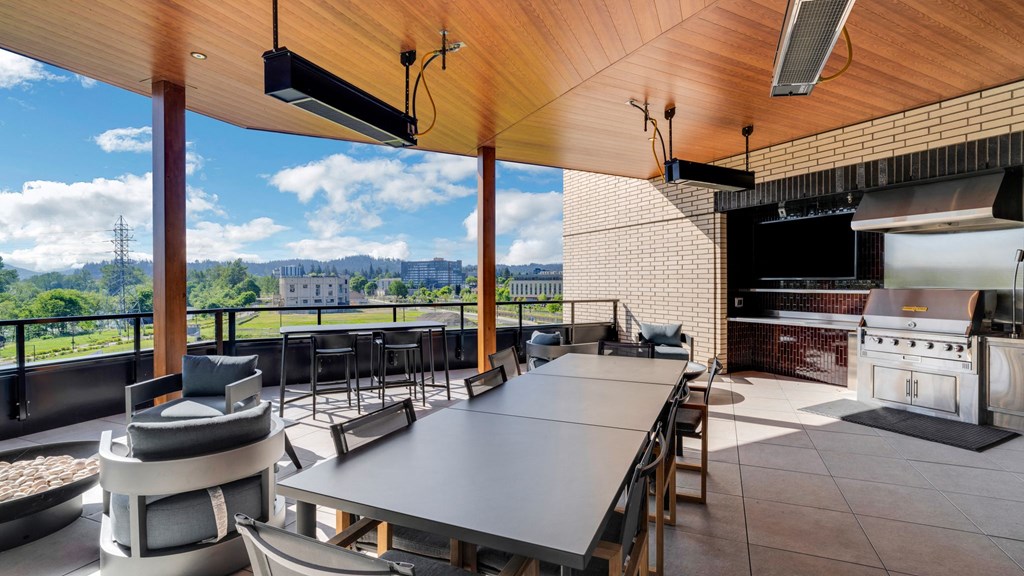 a dining area with a long table and chairs and a kitchen with a large window