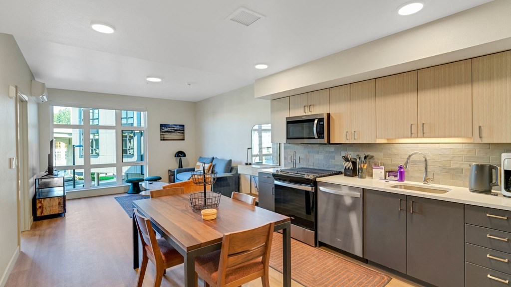 a kitchen with stainless steel appliances and a wooden table