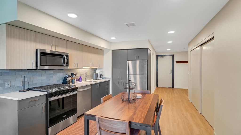 a kitchen with stainless steel appliances and a wooden table