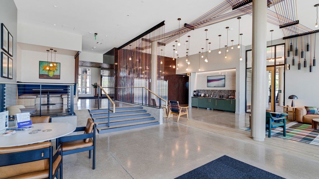 the lobby or reception area of a hotel with tables and chairs