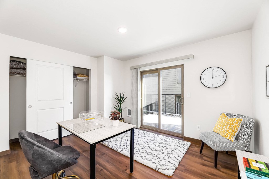 a living room with a table and a clock on the wall