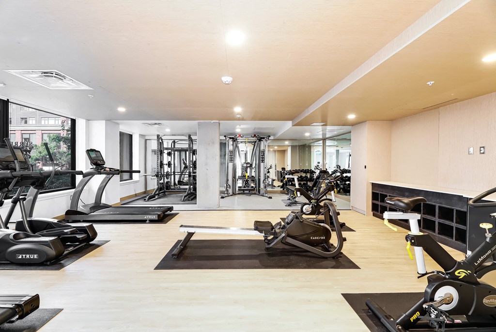 a gym with treadmills and other exercise equipment on the floor