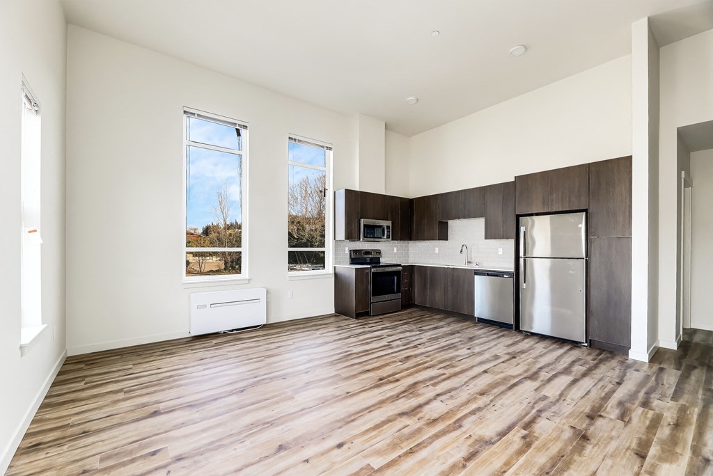 a kitchen and living room with hardwood floors and white walls