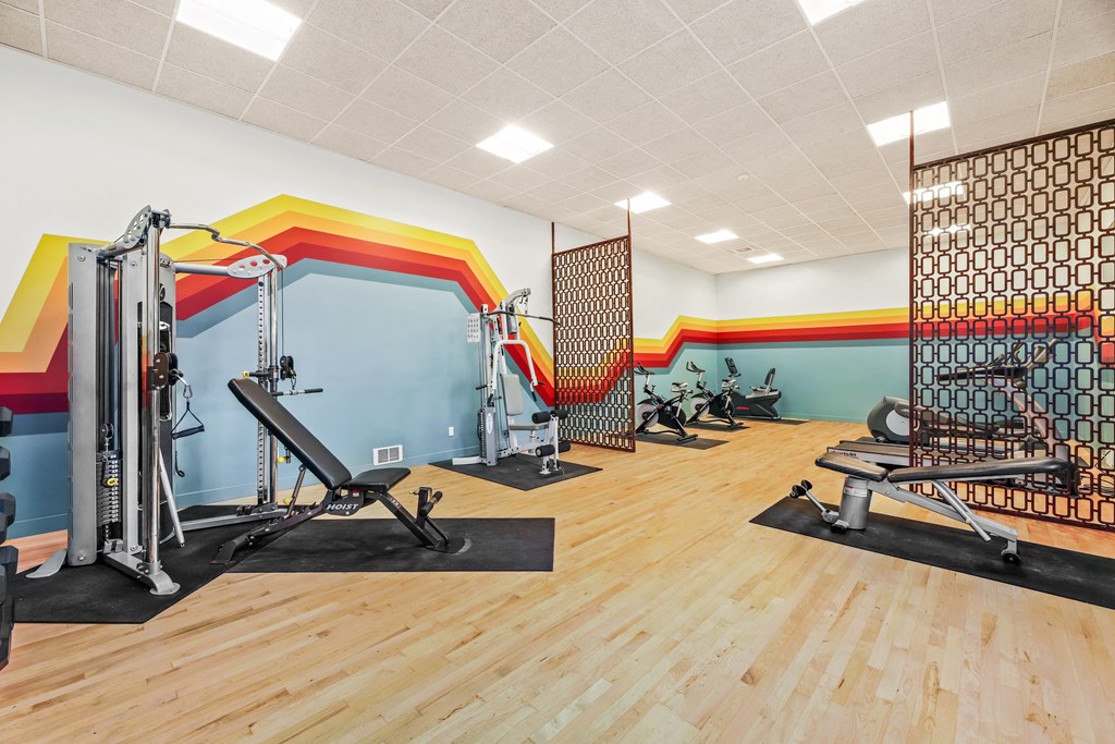 a gym with weights and other exercise equipment and a wall with graffiti