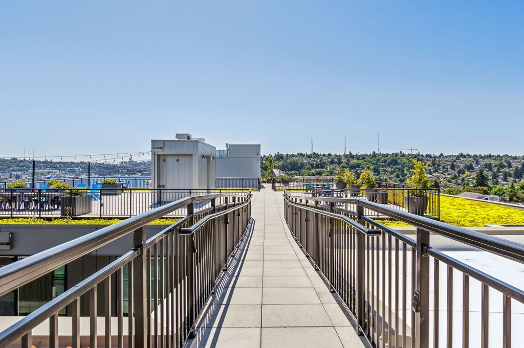 a walkway on top of a building with a view of a city in the background