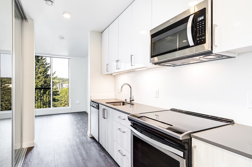 a kitchen with white cabinets and a stove and a microwave