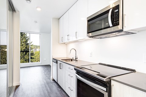 a kitchen with white cabinets and a stove and a microwave