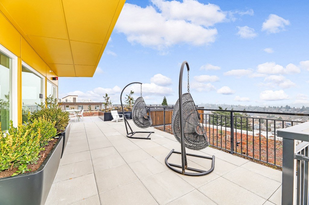 a balcony with two swing chairs and a view of the city