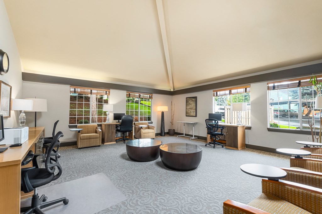 a large living room with tables and chairs and windows
