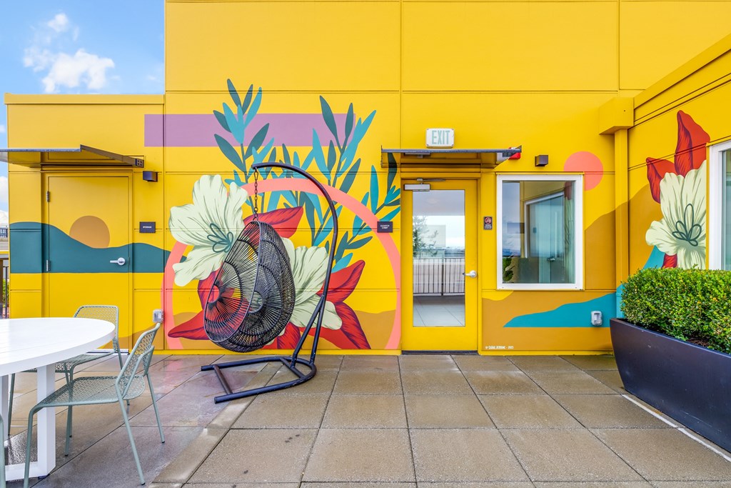 a yellow building with a mural of flowers on the wall