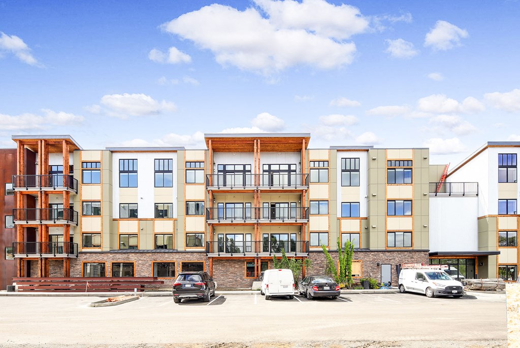 an image of an apartment building with cars parked in front of it