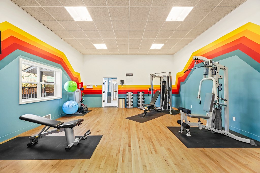 a fitness room with exercise equipment and colorful walls