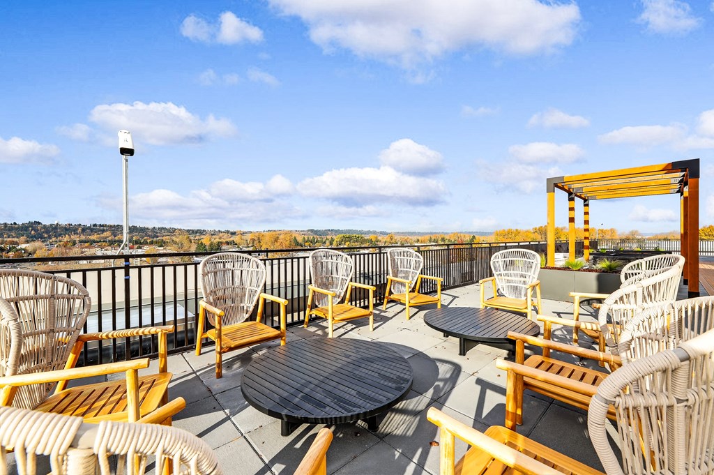 the deck on the roof of the building has tables and chairs