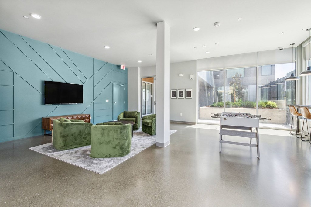 a living room with a table and chairs in front of a wall of windows