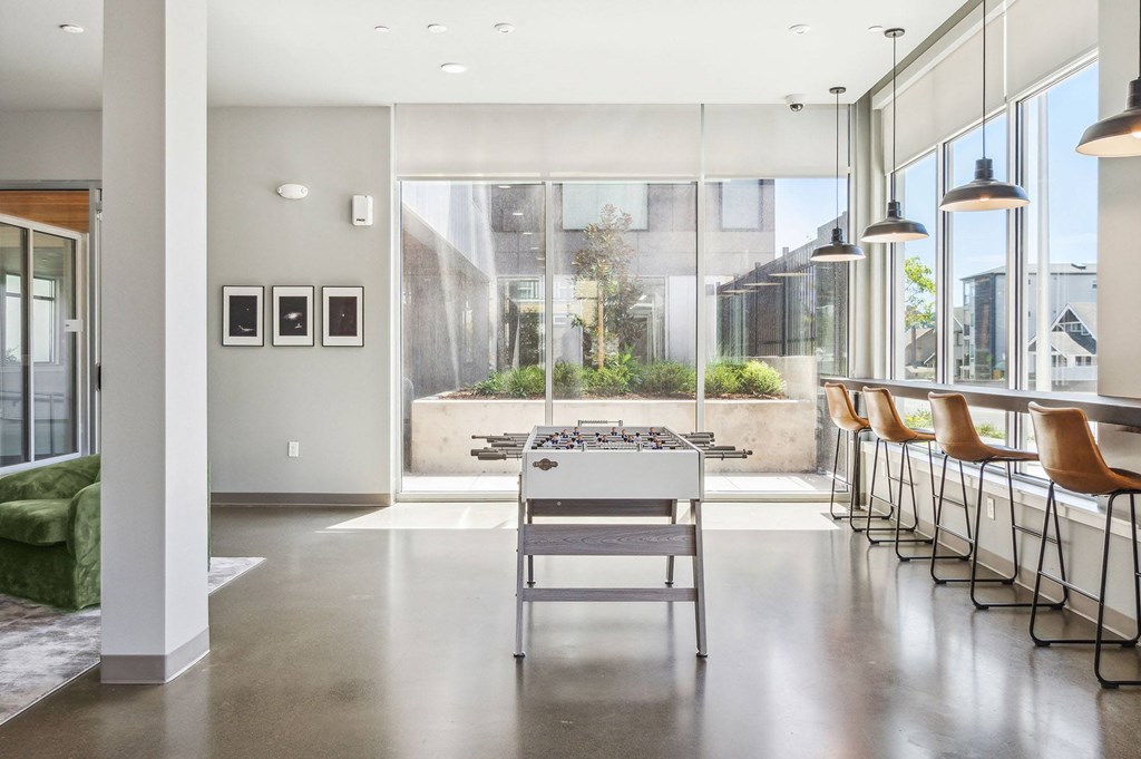 a foosball table sits in the middle of a large room with large windows
