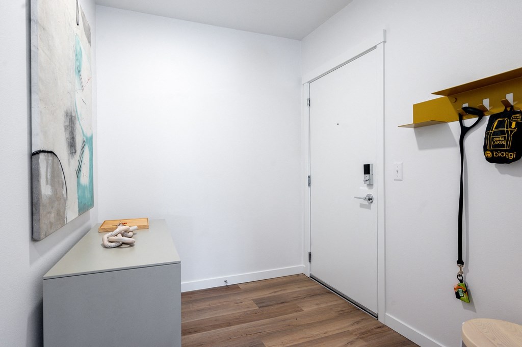 a room with white walls and a white door with a yellow shelf on top of it