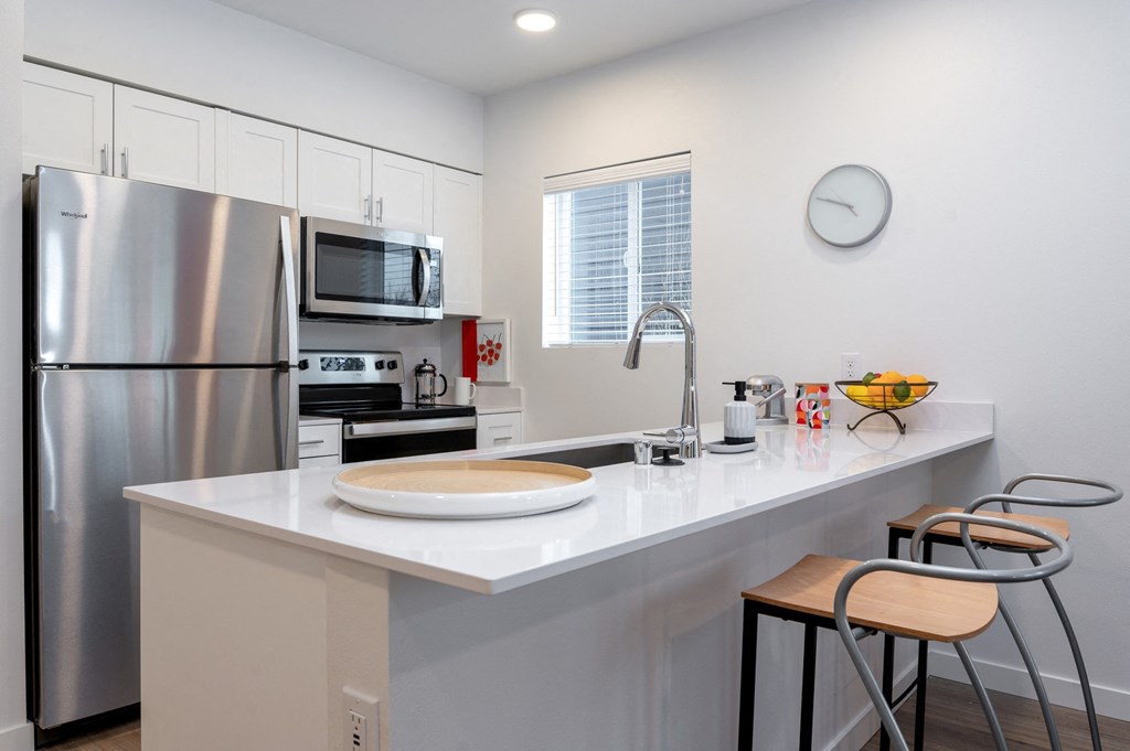 a kitchen with a large island with a sink and two stools