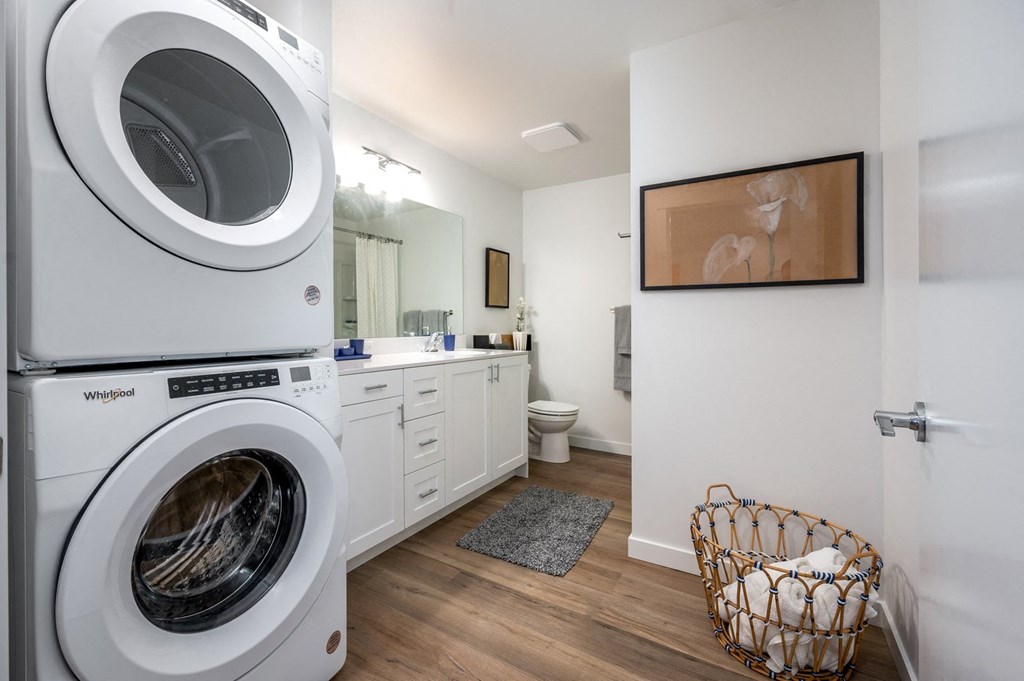 a washer and dryer in a bathroom with a sink and toilet