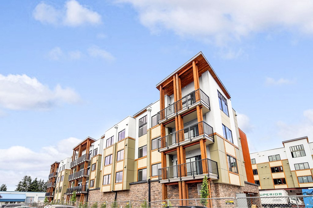 a row of apartments with balconies in front of a blue sky