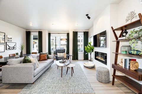 a living room with a gray couch and a fireplace