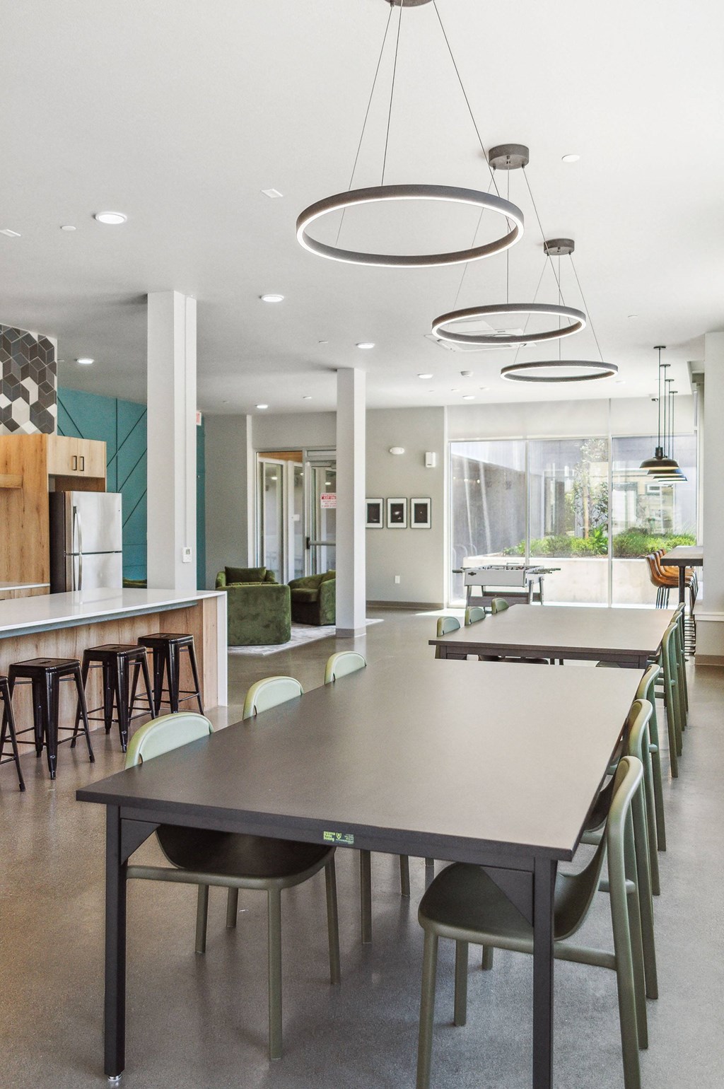 a long table with chairs and a kitchen in the background