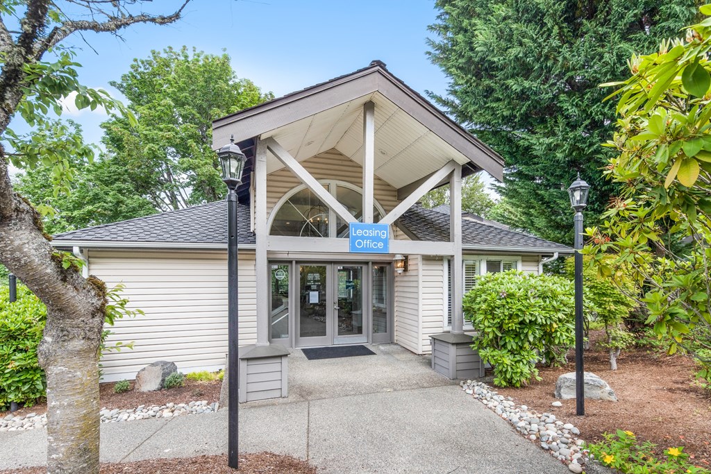 a white building with a gray roof and a blue sign on it