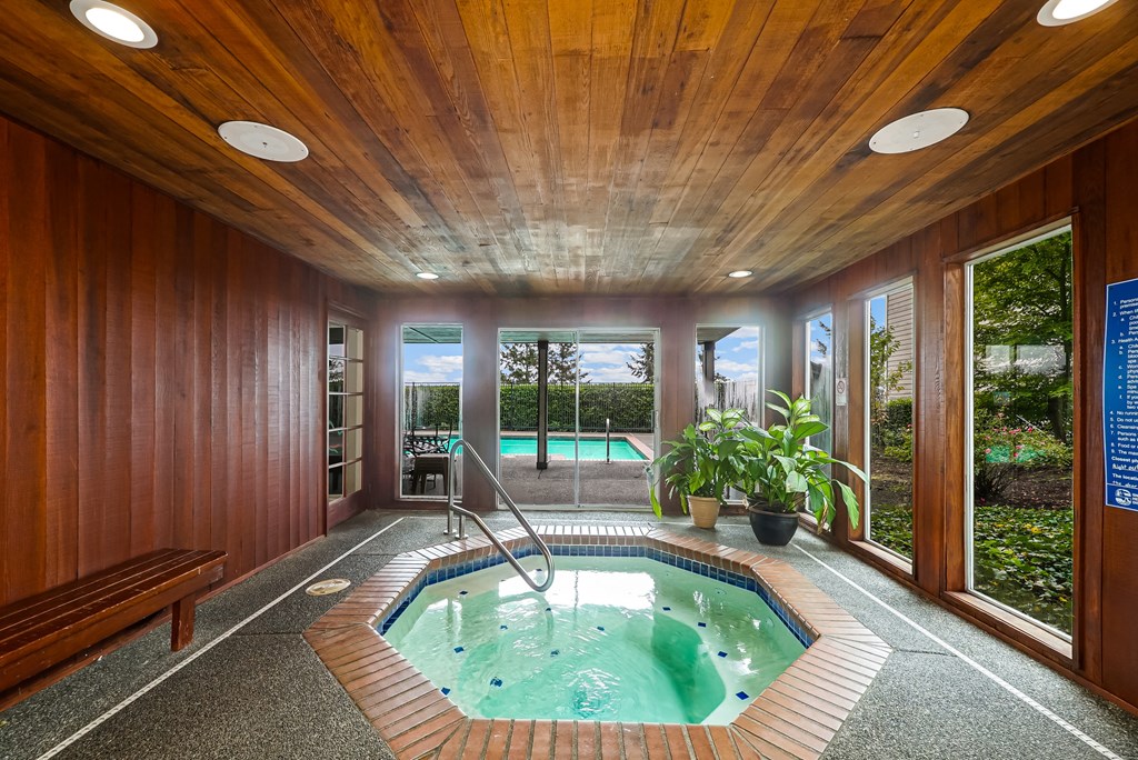 a swimming pool in a house with wooden walls and a wooden ceiling