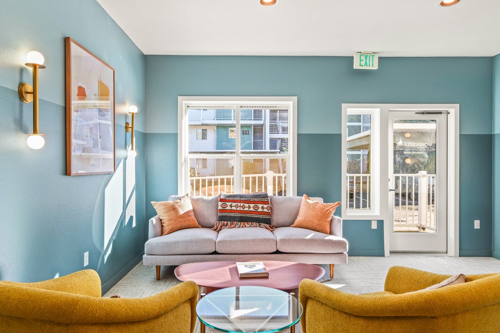 a living room with blue walls and a couch and chairs