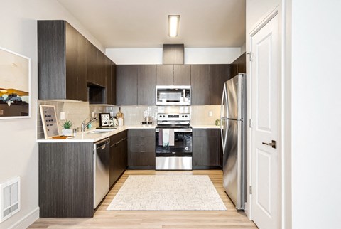 a kitchen with stainless steel appliances and dark wood cabinets
