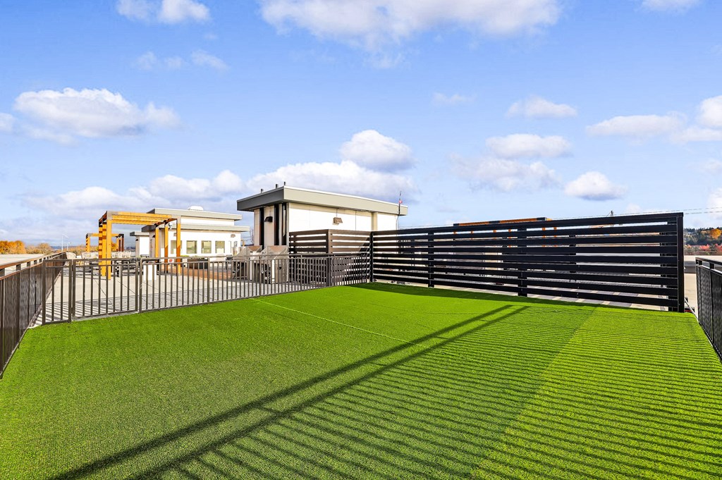 a green lawn on top of a building with a fence