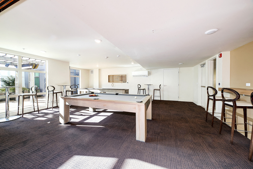 a games room with a pool table and chairs