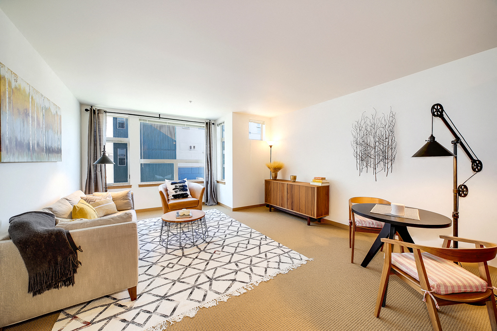 a living room with a couch and a table     and a window