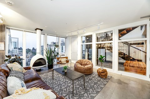 a living room with a brown leather couch and a fireplace