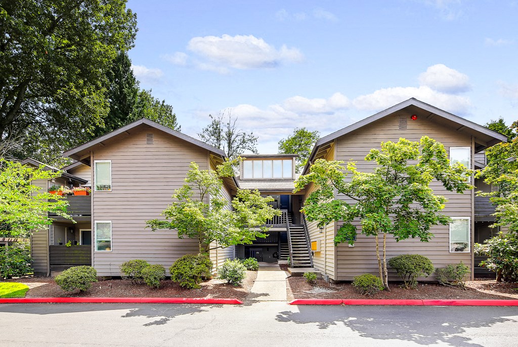 a house with a red curb and trees in front of it