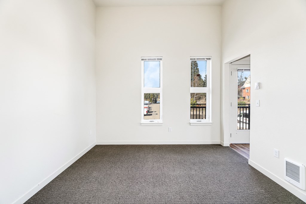 a bedroom with a carpeted floor and three windows