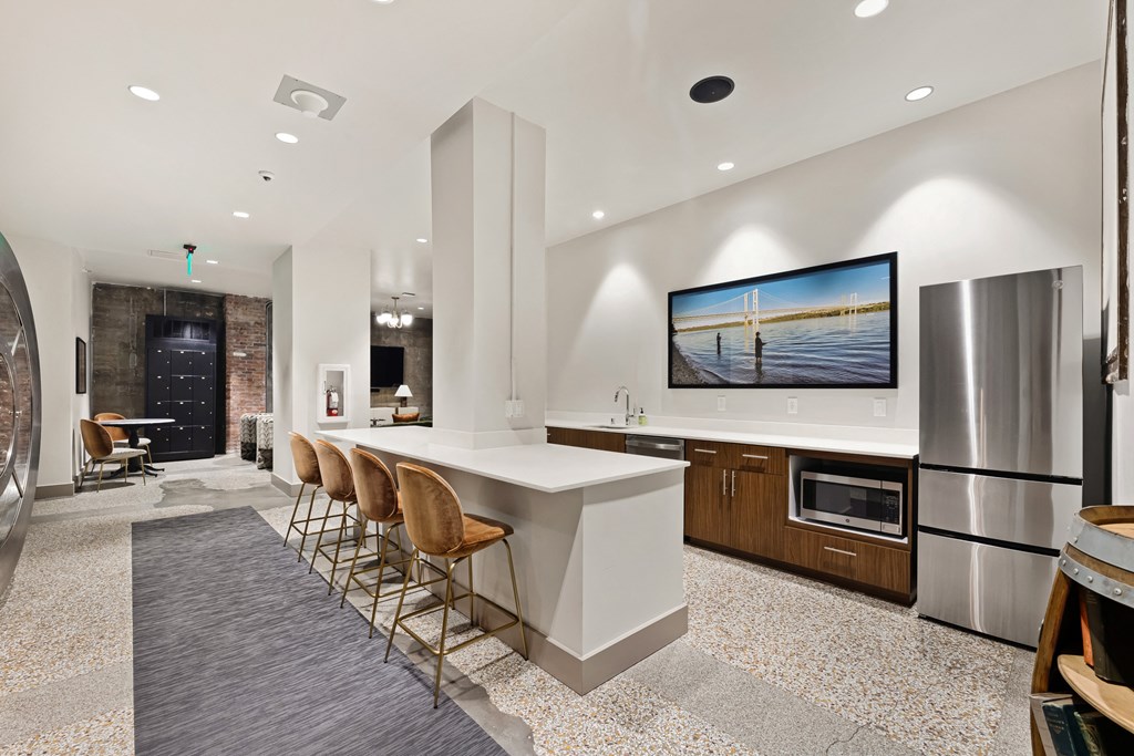 a kitchen with a large center island with a breakfast bar underneath a flat screen tv