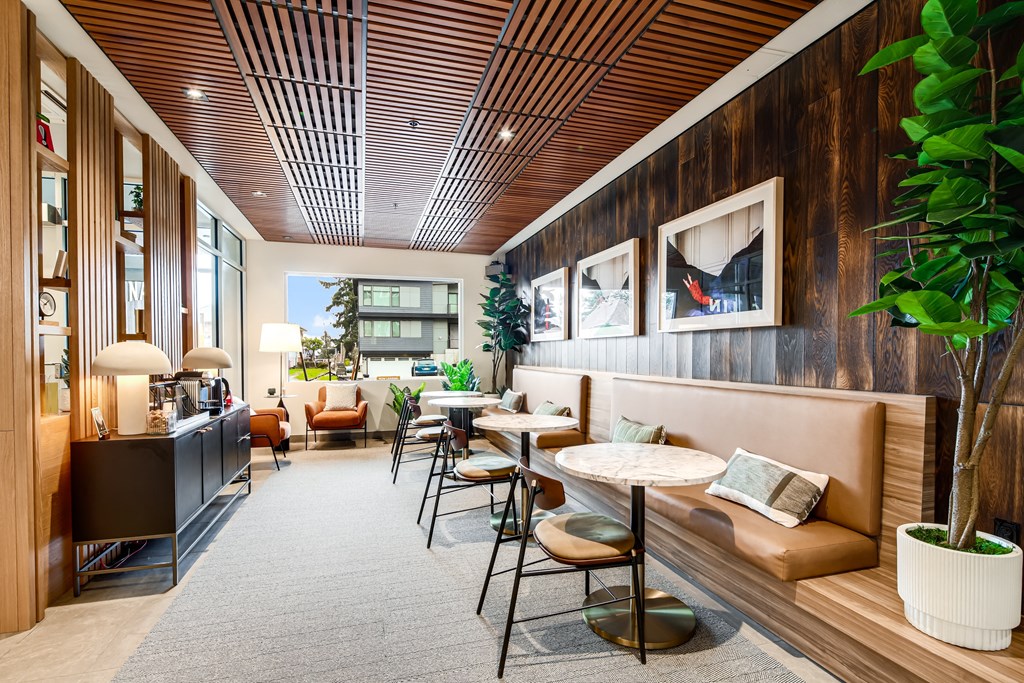 the lobby of a hotel with tables and chairs and a bar