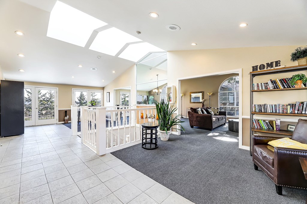 a living room with a white staircase and a bookcase