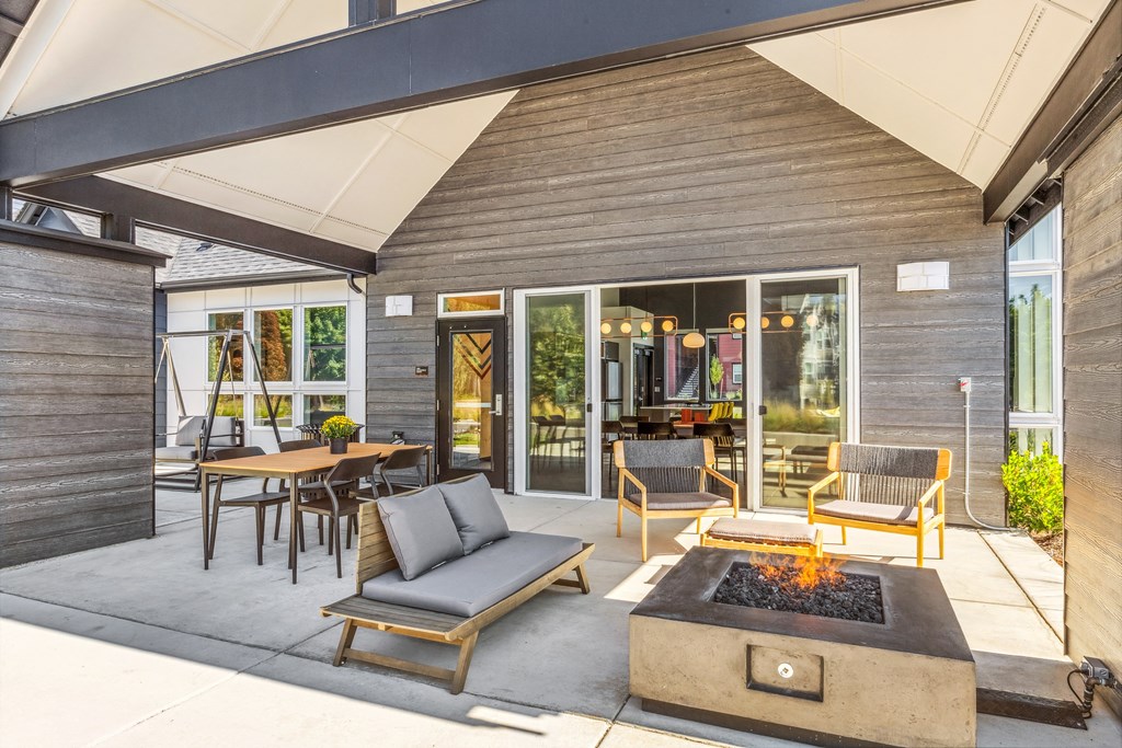 a patio with a fire pit and chairs and tables