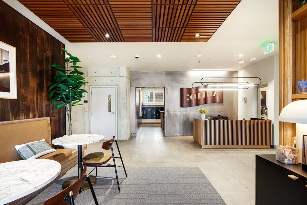 the lobby of a hotel with tables and chairs and a reception desk