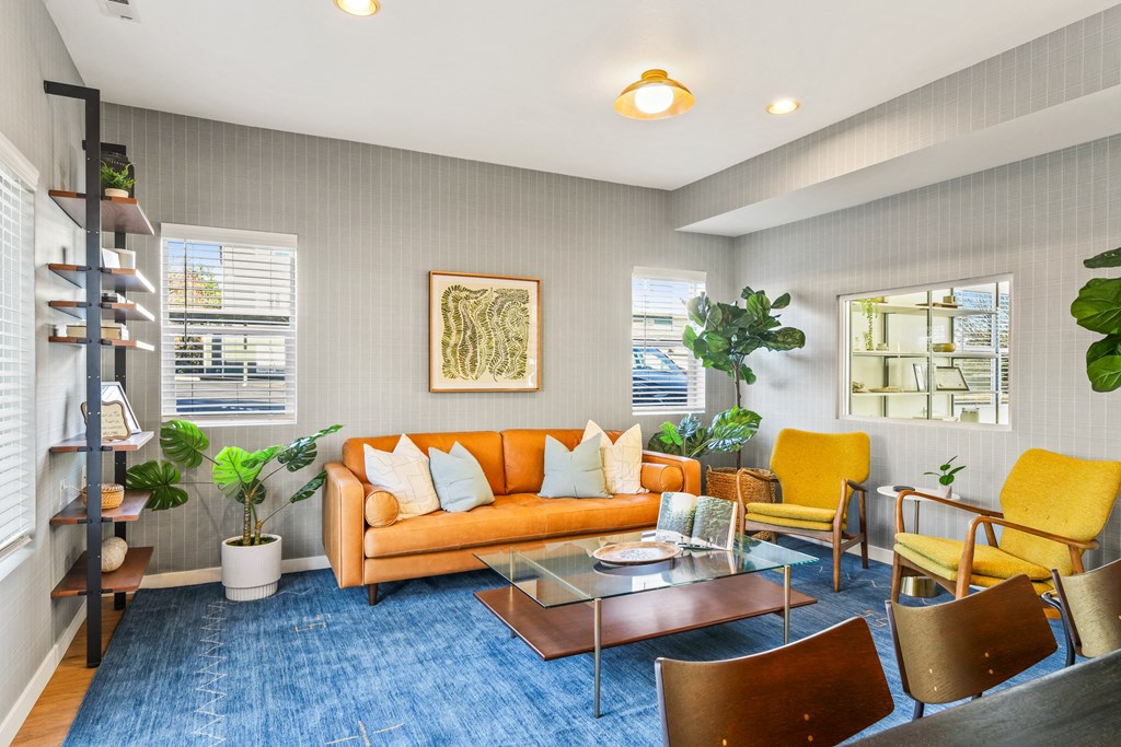 a living room with a orange couch and a glass coffee table