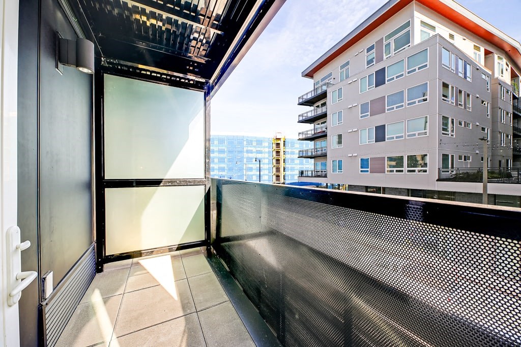 a balcony with a view of a building and the ocean