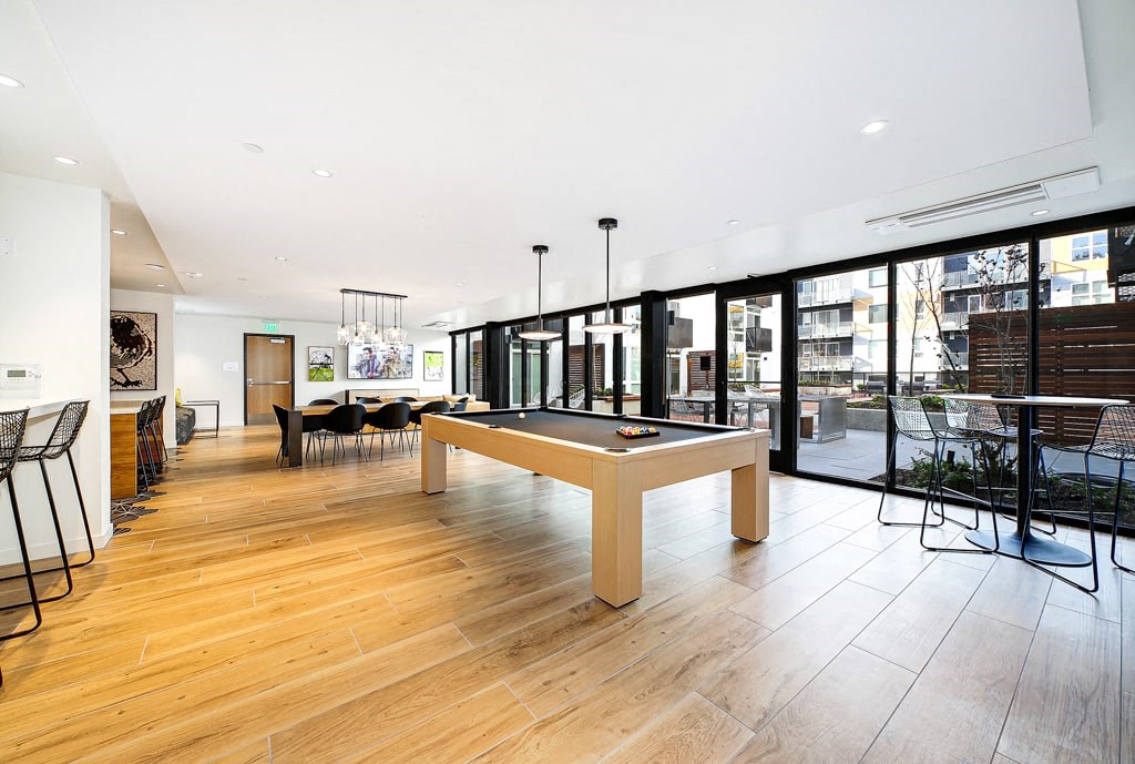 a large living room with a pool table in the middle